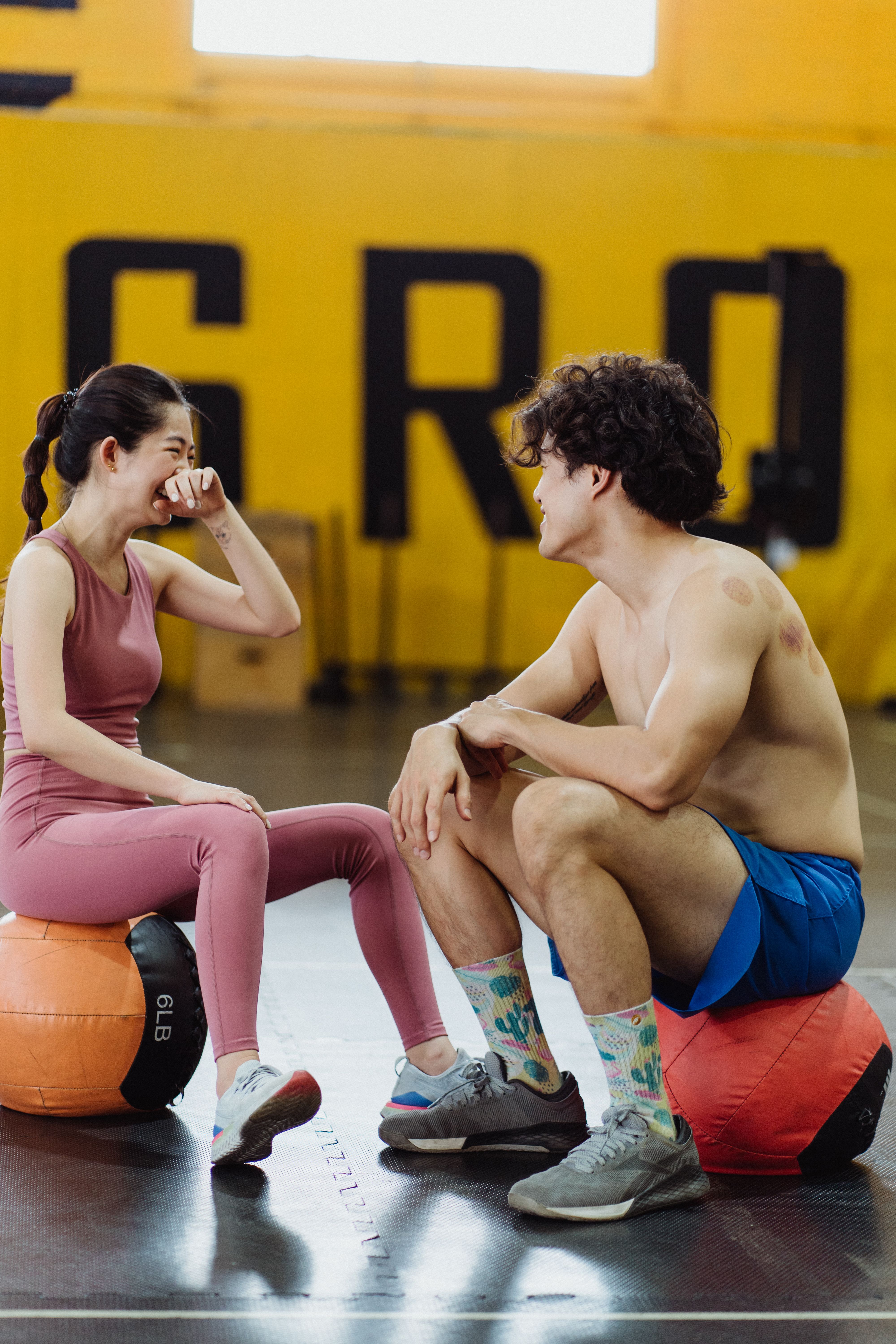 Couple laughing together between sets at the gym
